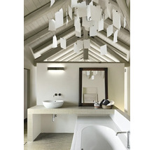 Koupelna s umyvadlem, zrcadlem, vanou a dekorativním osvětlením pod šikmou střechou