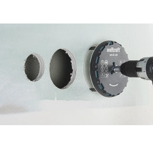 Děrovka Wolfcraft s vrtačkou vrtá otvory do zdi.