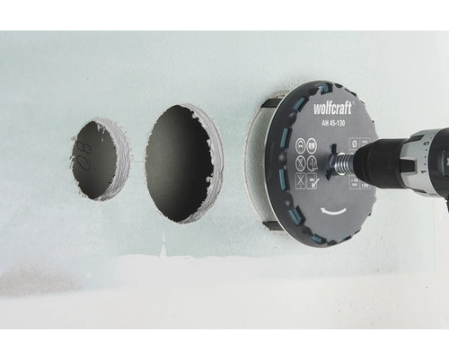 Děrovka Wolfcraft s vrtačkou vrtá otvory do zdi.