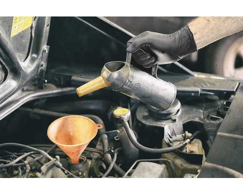 Motorový olej se doplňuje pomocí trychtýře a olejničky