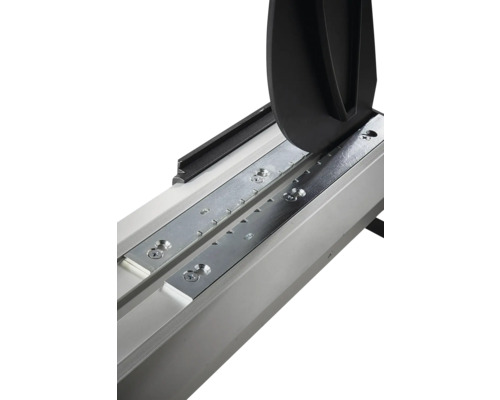 Detail řezačky na obklady s vodicí lištou, kovovými deskami a lámacím mechanismem.