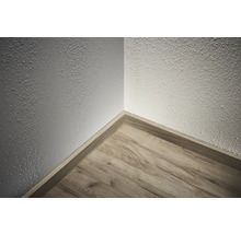 Roh místnosti s dřevěnou podlahou a podlahovou lištou