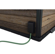 Detail zahradního domku s elektrickou přípojkou a dřevěnou stěnou