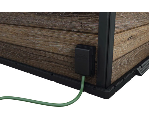 Detail zahradního domku s elektrickou přípojkou a dřevěnou stěnou