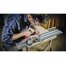 Muž řeže obrobek ponornou pilou Einhell.