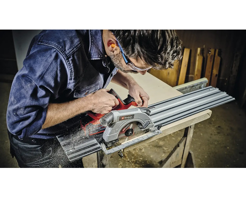 Muž řeže obrobek ponornou pilou Einhell.