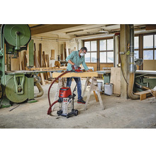 Dílna s řemeslníkem, bruska, dřevěný trám, pracovní stůl, průmyslový vysavač a pásová pila