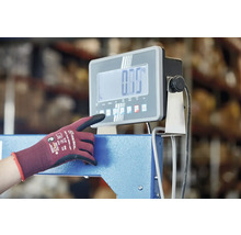 Osoba obsluhuje digitální průmyslovou váhu s pracovní rukavicí