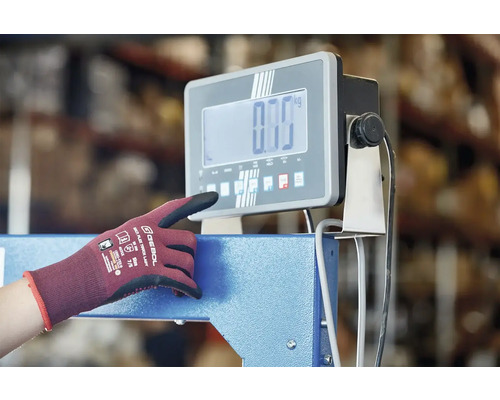 Osoba obsluhuje digitální průmyslovou váhu s pracovní rukavicí