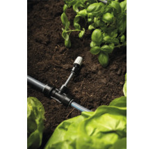 Zavlažovací systém s T-kusem a rostlinami v zahradním záhonu