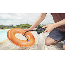 Osoba nafukuje plavecký kruh pomocí vzduchové pumpy Bosch vedle bazénu.