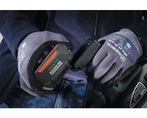 Osoba v pracovních rukavicích drží baterii Bosch 18V