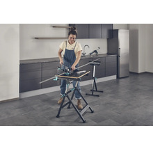 Žena pracuje s pracovní lavicí a pokosnicí v místnosti.