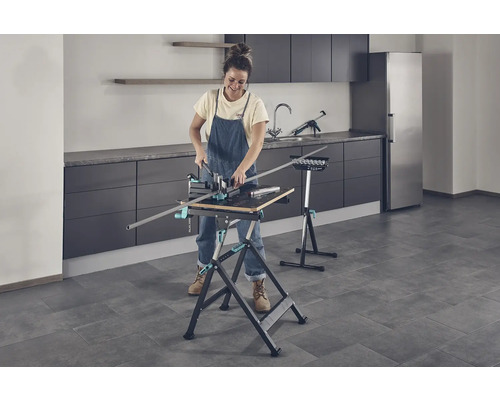 Žena pracuje s pracovní lavicí a pokosnicí v místnosti.