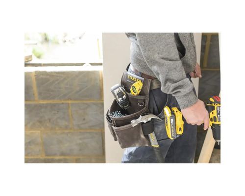 Řemeslník s brašnou na nářadí plnou nářadí a elektrického nářadí