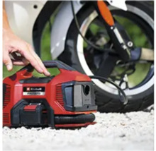 Červený akumulátorový kompresor Einhell před motocyklem