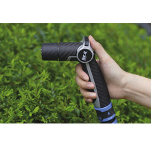 Ruka drží zahradní stříkací pistoli značky For Q před zeleným keřem