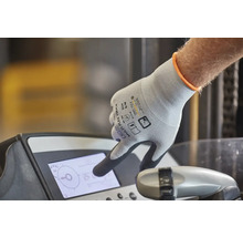 Ruka s pracovní rukavicí ovládá displej