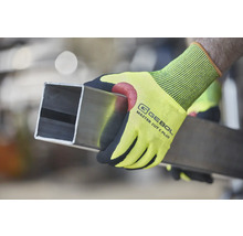 Osoba drží čtyřhrannou trubku v pracovních rukavicích Gebol Master Cut C Plus.