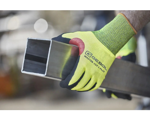 Osoba drží čtyřhrannou trubku v pracovních rukavicích Gebol Master Cut C Plus.