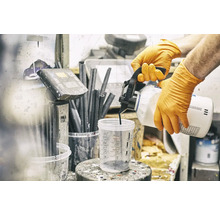 Osoba v rukavicích nalévá barvu do odměrky