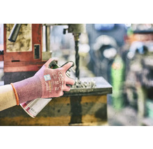 Osoba pracuje s vrtačkou a nosí pracovní rukavice pro ochranu.