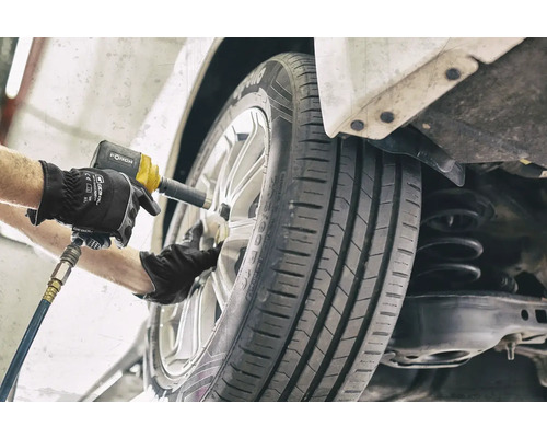 Mechanik mění kolo pomocí rázového utahováku.