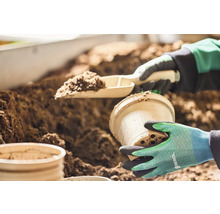 Zahradnická scéna s lopatkou na rostliny, květináčem a zeminou