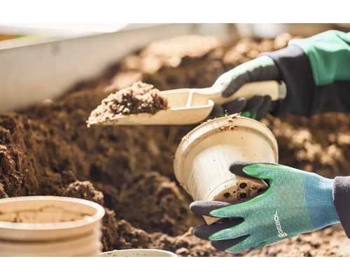 Zahradnická scéna s lopatkou na rostliny, květináčem a zeminou