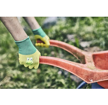 Práce na zahradě se zahradními rukavicemi a konví