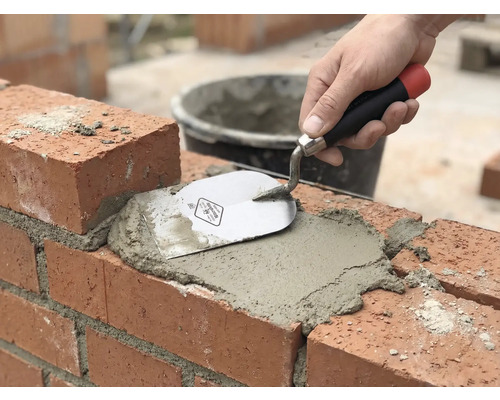 Zednické práce: Cihla je spárována maltou a zednickou lžící.