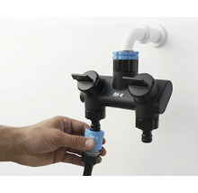 Fotografie dvojité baterie for_q s přípojkou vody a rukou připevňující hadici.