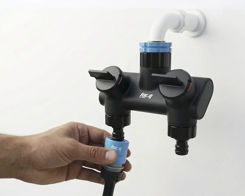 Fotografie dvojité baterie for_q s přípojkou vody a rukou připevňující hadici.