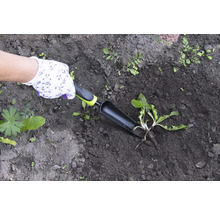 Zahradničení sázecí lopatkou v tmavé zemi, chráněné zahradními rukavicemi.