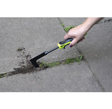 Ruka používá škrabku na spáry k odstraňování plevele mezi dlažebními kameny.