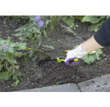Osoba používá malé hrábě k zahradničení