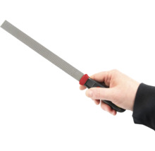 Ruka drží rašpli s rukojetí