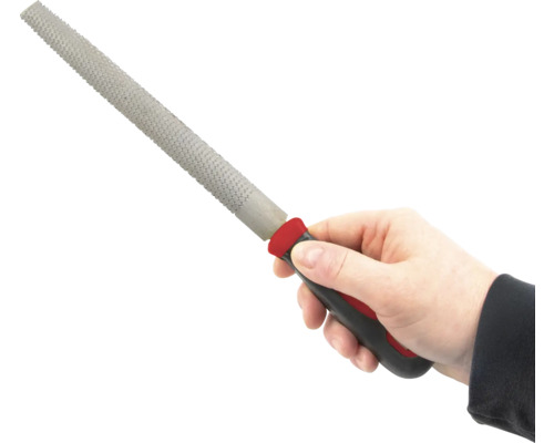 Ruka drží rašpli s plastovou rukojetí