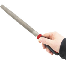 Ruka drží hladký pilník s rukojetí