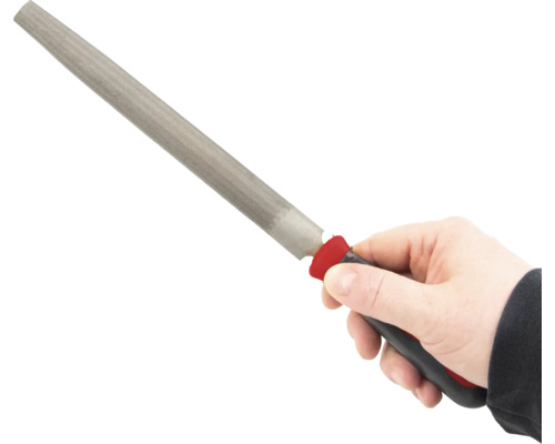 Ruka drží hladký pilník s rukojetí