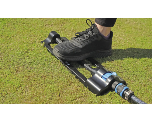 Zahradní zavlažovač ovládaný nohou na trávníku