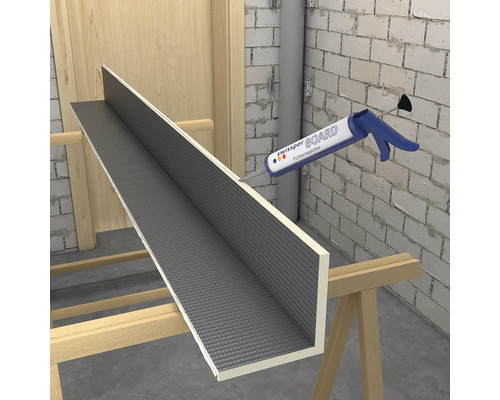 Rohový prvek Swisspor BOARD na kozách při nanášení polyuretanového montážního lepidla pomocí tmelicí pistole.