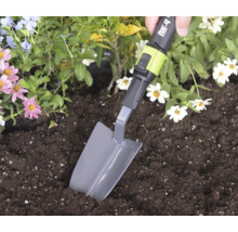 Ruka používá sázecí lopatku for_q ke kopání v hlíně v květinovém záhonu.