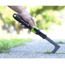 Škrabka na spáry for_q fitconnect při odstraňování plevele mezi dlaždicemi na cestě.