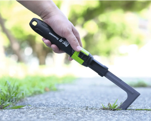 Škrabka na spáry for_q fitconnect při odstraňování plevele mezi dlaždicemi na cestě.