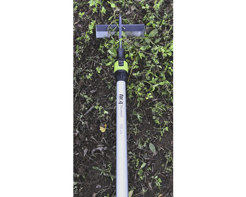 Kyvná motyka for_q fitconnect s hliníkovou násadou o délce 150 centimetrů na půdě s plevelem.