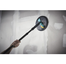 Ruční bruska Wolfcraft s teleskopickou násadou při broušení vytmelené sádrokartonové stěny.