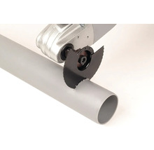 Multifunkční nářadí s kotoučovou pilou řeže plastovou trubku.