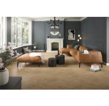 Prostorný moderní obývací pokoj s podlahou v dekoru dřeva se vzorem rybí kosti, stěnami s ozdobnými lištami, koženou pohovkou a krbem.