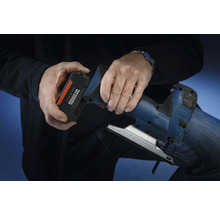 Osoba vkládá akumulátor ze systému Bosch Professional 18 voltů do přímočaré pily.